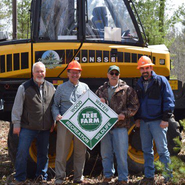 Forestry specialists in front of construction equipment